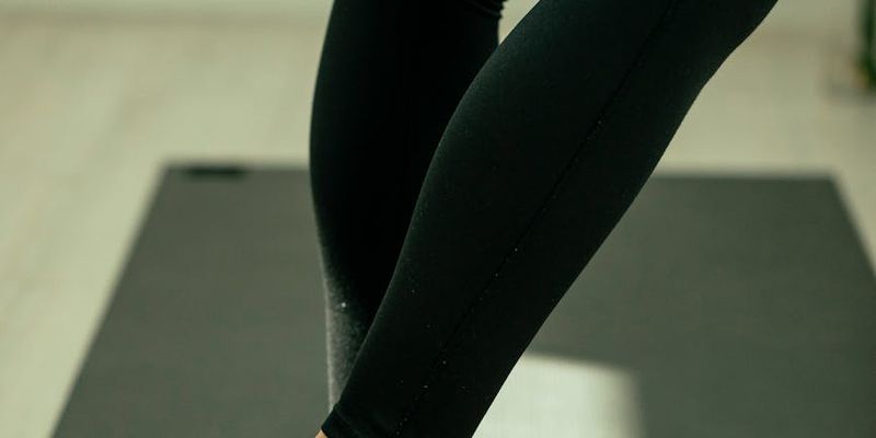 Corner of a calm room with a rolled-up yoga mat and a plant.